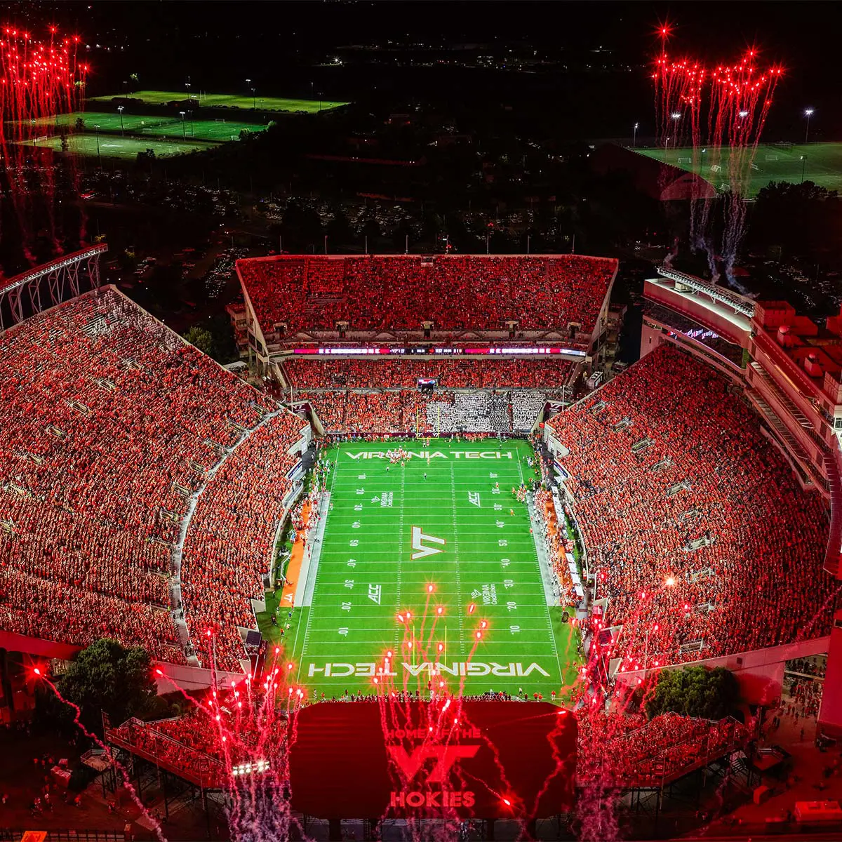Aerial view of packed football stadium with fireworks going off